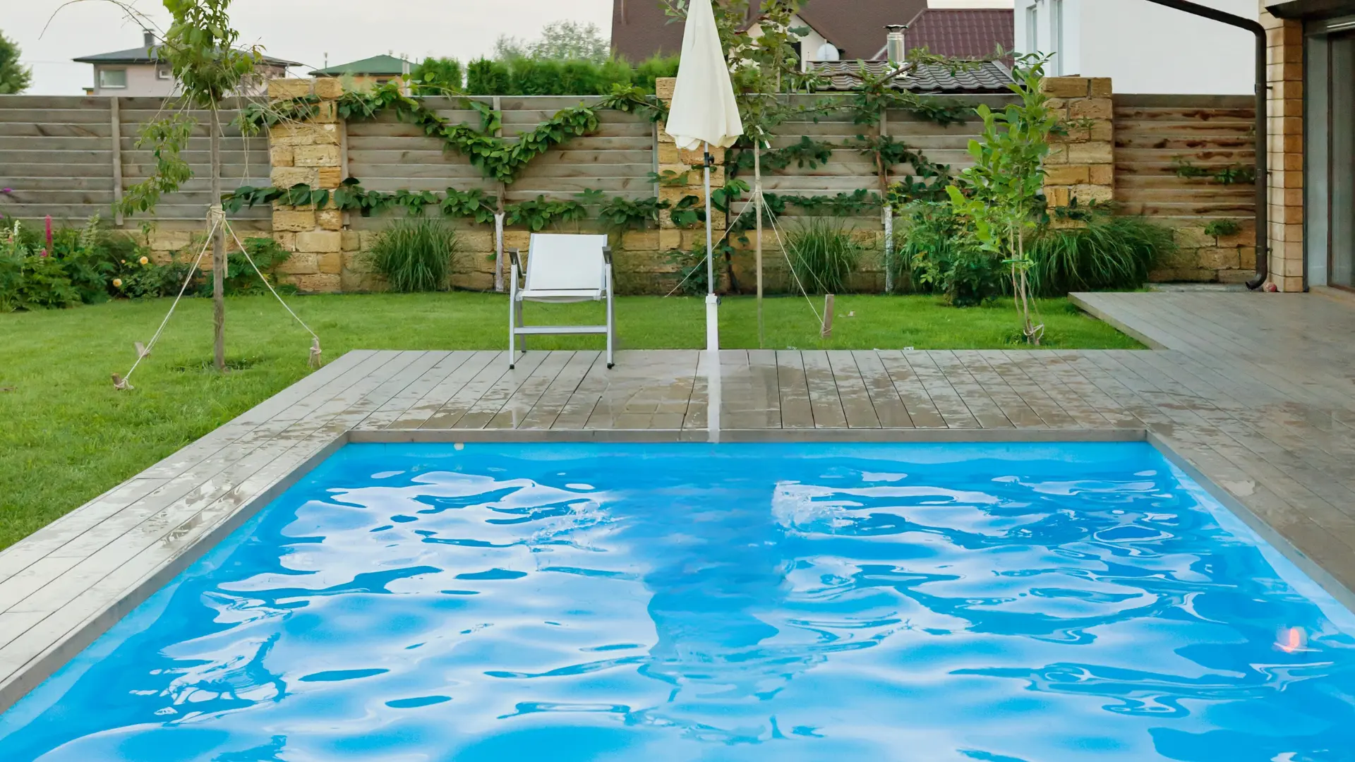 Compact rectangular pool set flush with a wood deck surround